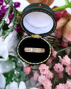 an open ring box sitting on top of flowers