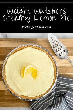 a lemon pie sitting on top of a wooden cutting board