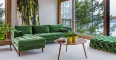 a green couch sitting next to a wooden table