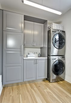 a washer and dryer in a room with wood flooring on the ground