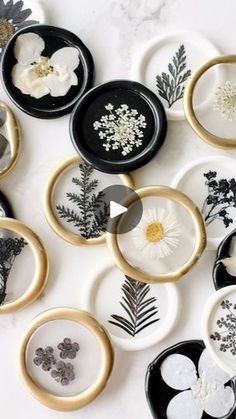 a collection of black and white plates with flowers on them, all decorated in gold rims