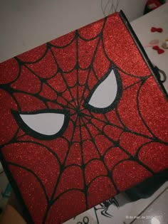 a close up of a red and black box with a spiderman face on it