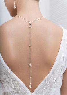 the back of a woman's dress with pearls on it