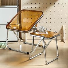 a chair and table sitting on top of a hard wood floor next to a wall