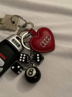 a car keychain with two dices and a heart shaped key chain attached to it