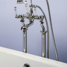 a white bath tub sitting under a faucet next to a wall mounted shower head