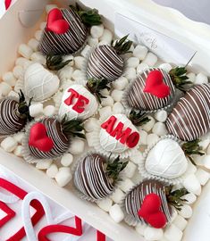 a box filled with chocolate covered strawberries on top of white rocks and red hearts