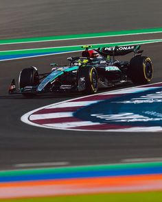 a man driving a racing car on top of a race track