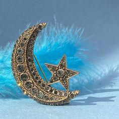 ● Are you looking for the perfect gift for yourself or your loved one? Our Crescent and Star Brooch, designed with crystal stones on bronze, may be the perfect choice for you. ● This Crescent and Star brooch is inspired by the Moon that illuminates us at night and the Stars that shine brightly in the sky, and is decorated with crystal stones on bronze. Its width is 4 cm and its height is 5.5 cm, which makes it a statement piece that adds elegance and sophistication to any outfit. ● Our product design is a product of Tansel Baybara's Diplomatic Heritage Collection. The brooch is meticulously handcrafted and the white crystal stones are hand-set by women, making our brooch a perfect piece of jewellery. ● Your Crescent and Star Brooch will arrive in a special velvet box, ready to be given as Wedding Brooches, Star Brooch, Wedding Brooch, Crystal Stones, Crystal Brooch, Heritage Collection, White Crystal, Perfume Spray, Black Crystals