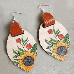 Bring sunshine to your style with our beautiful wood and leather sunflower earrings. These charming accessories are the perfect statement piece for any nature lover or bohemian fashionista. 3 inches long Painted Leather Earrings, Leather Sunflower, Copper Painting, Wooden Leaf, Wood Earring, Wood Disc, Sunflower Earrings, Snap Jewelry, Wooden Earrings