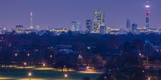 the city skyline is lit up at night, with lights shining in the foreground