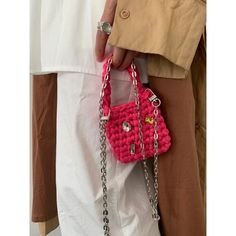 a person holding a pink purse with chains on it