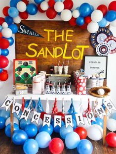 a table with balloons and decorations for a small sandlot birthday party on the beach