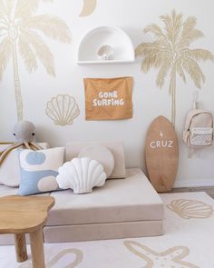 a child's room with palm trees on the wall and surfboards hanging from the ceiling