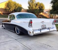 an old white car parked in front of a house