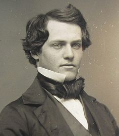 an old black and white photo of a man in a suit with a bow tie