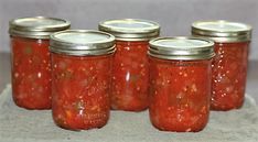 six jars of canned tomato sauce sitting on a towel