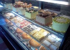 a display case filled with lots of different types of cakes