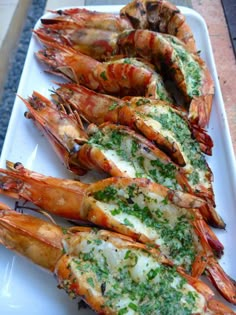 grilled shrimp with parsley and garlic on a white platter