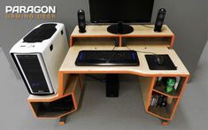 a computer desk with a monitor, keyboard and speakers on it next to a desktop