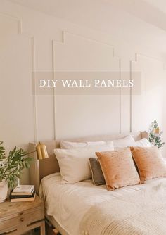 a white bed sitting next to a window with the words diy wall panels above it