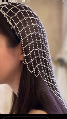 a woman with long hair wearing a head piece made out of pearls and beads on her head