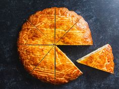 a piece of pie with one slice cut out and the other half eaten on a black surface