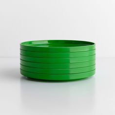 a stack of green plates sitting on top of a white table