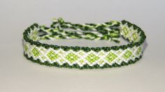 two green and white bracelets sitting on top of each other