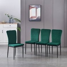 a set of four green chairs sitting next to each other in front of a wall