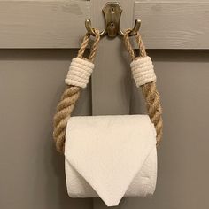 a white towel hanging from a hook on a wooden door with rope wrapped around it