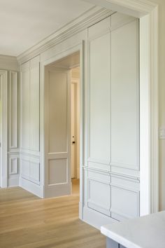 an empty room with white walls and wood floors