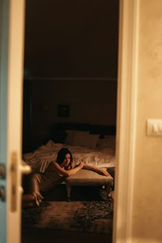 a woman laying on top of a bed in a bedroom next to a blue door