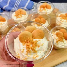 small desserts in plastic cups with orange sprinkles on top and white frosting