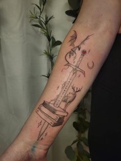 a tattoo on the arm of a woman with a knife in it's center