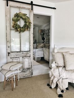 an old door is open to reveal the farmhouse decor in this living room with white furniture and pillows