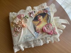 an altered photo frame with lace and flowers on it's edge, sitting on a table