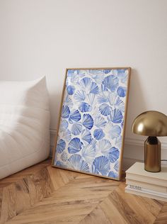 a blue and white flower print on a wall next to a lamp