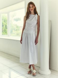 This elegant maxi skirt features a voluminous A-line silhouette, creating a graceful and flowing appearance. The skirt is designed with a high waist and ample gathers, which enhance its fullness and movement. It is made from a soft, lightweight fabric that drapes beautifully, making it perfect for both casual and formal occasions. The elastic waistband ensures a comfortable and adjustable fit, accommodating a range of body sizes.- The high waist and gathered design of the skirt accentuate the waistline and provide a flattering shape.- Its classic black color adds versatility, allowing it to be paired easily with various styles of tops and accessories.- The maxi length and fluid drape of the skirt offer a timeless elegance, suitable for a variety of settings from day-to-night wear. Chic A-line Maxi Skirt For Daywear, White Midi Length Voluminous Maxi Skirt, Chic Dress With Relaxed Gathered Skirt, Chic Relaxed Dress With Gathered Skirt, Chic Spring Draped And Gathered Skirt, Chic White Ruched Maxi Skirt, Spring Maxi Dress With Voluminous Flared Skirt, Chic Flowy Maxi Skirt With Folds, White Maxi Dress With Relaxed Fit