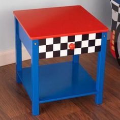 a red and blue side table sitting on top of a wooden floor next to a toy car