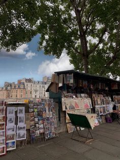 there are many newspaper stands on the side of the street with trees and buildings in the background