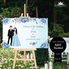 an easel with a wedding photo on it in front of flowers and greenery