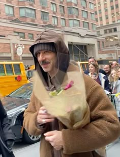 a man in a brown coat is walking down the street