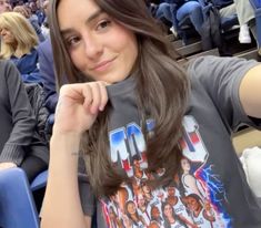 a woman sitting in the stands at a basketball game