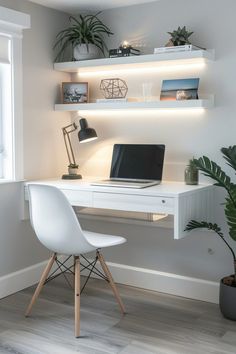 a white desk with a laptop on it and some plants in front of the window