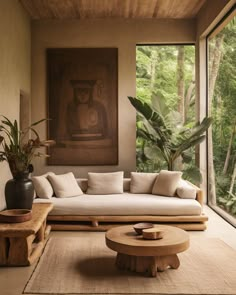 a living room filled with furniture next to a large window covered in plants and trees