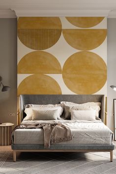 a large bed sitting in front of a wall with circles painted on it