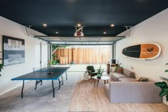 a living room filled with furniture and a ping pong table