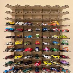 a wall mounted toy car display with multiple cars on it's sides and shelves