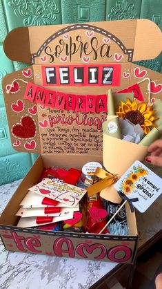 a cardboard box filled with valentine's day greeting cards and other items sitting on top of a table